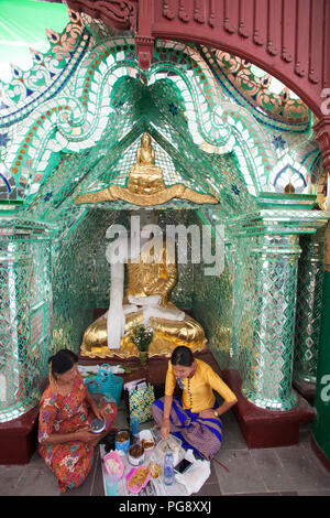 Women eating inside the  Chanthargyi Buddha image temple, Shwedagon pagoda, Yangon, Myanmar, Asia Stock Photo