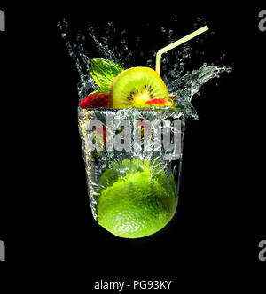 Cocktail with mint, strawberry and kiwi fruit in imaginary glass out of water splashes from lime fruit on black background Stock Photo