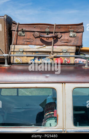 Old suitcases on a 1954 Ford Country Squire station wagon at a vintage retro festival. UK Stock Photo