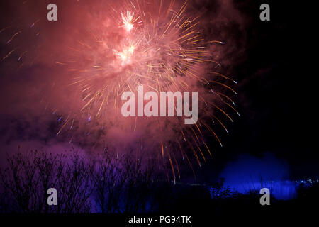 NIAGARA FALLS, ONTARIO, CANADA - MAY 20th 2018: Niagara Falls lit at night by colorful lights with fireworks Stock Photo