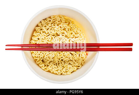 red chopsticks over open cup with dried instant noodles isolated on white background Stock Photo