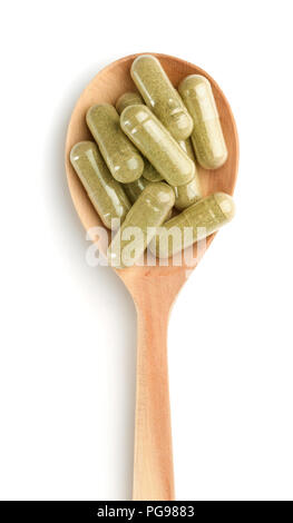 Top view of wooden spoon full of herbal capsules Stock Photo