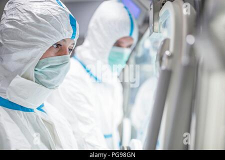 Technicians working in sealed, sterile isolator units in a laboratory that manufactures human tissues for implant. Such tissues include bone and skin grafts. Stock Photo