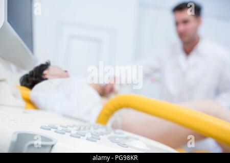 Woman having an ultrasound scan of her abdomen. Stock Photo