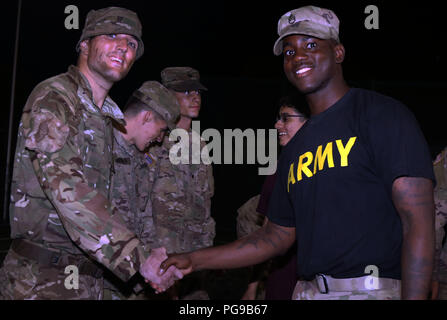Staff Sgt. Meegal Downer [right], an infantryman with the 1st Squadron, 2nd Cavalry Regiment congratulates U.K. army Lance Cpl. Marcus Rowlands [left] for earning his silver spurs during a spur ride ceremony Aug. 18 at Bemowo Piskie Training Area, Poland. BPTA Soldiers participated in a time-honored cavalry tradition that gave cavalry troops and partner nation participants the opportunity to earn and wear their silver spurs. The Soldiers are on a six-month rotational assignment in support of the multinational battle group comprised of U.S., U.K., Croatian and Romanian Soldiers who serve with t Stock Photo
