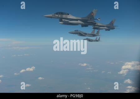 Romanian F-16 Fighting Falcons fly in formation with Massachusetts Air National Guard 131st Expeditionary Fighter Squadron F-15C Eagles above Bucharest, Romania, Aug. 20, 2018. The U.S. works closely with Romania on a range of global challenges, including promoting international peace, security and economic prosperity. (U.S. Air Force photo by Senior Airman Dawn M. Weber) Stock Photo