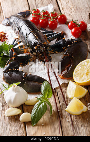 Seafood raw food: lobster with vegetables, herbs and spices close-up on the table. vertical Stock Photo
