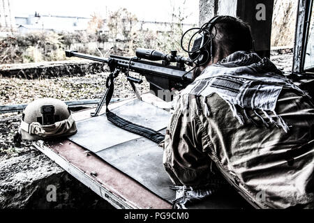 Army sniper in combat readiness on firing position Stock Photo