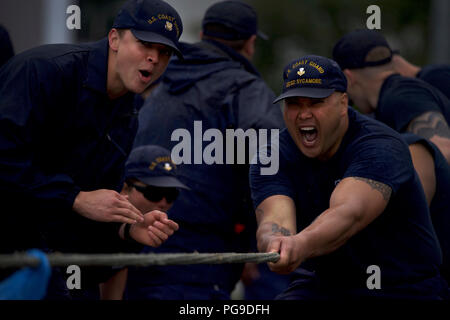 Members of the Coast Guard Cutter Sycamore fight passed the point of exhaustion during the tug-o-war competition as part of the Buoy Tender Olympics at Coast Guard Station Juneau, Alaska, Aug. 22, 2018. The Olympics is a competition that not only builds morale amongst cutter members but also provides a fun alternative to every day training in events such as the chain pull, survival swim and the heat-and-beat. U.S. Coast Guard photo by Petty Officer 1st Class Jon-Paul Rios. Stock Photo