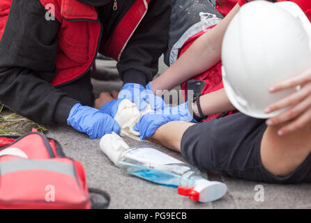 First aid training with simulation of workplace accident and helping  injured worker Stock Photo
