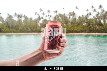 Can of Balboa, local beer brand of Panama, being held by millennial male traveler in the San Blas Islands, in the Caribbean Stock Photo