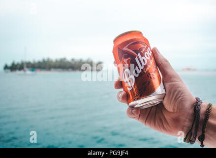 Can of Balboa, local beer brand of Panama, being held by millennial male traveler in the San Blas Islands, in the Caribbean Stock Photo