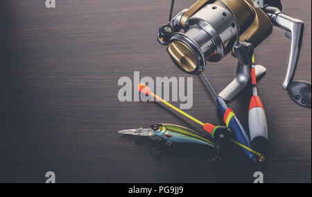 Coil and floats for a fishing rod on a wooden background Stock Photo