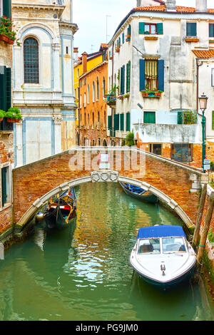 Small canal with moored motorboats in Venice, Italy Stock Photo