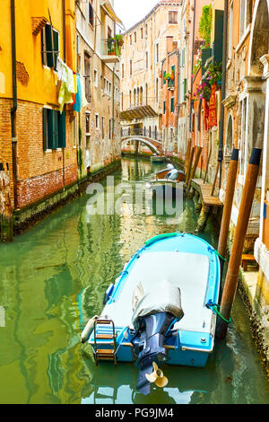 Small side canal with moored motorboats in Venice, Italy Stock Photo