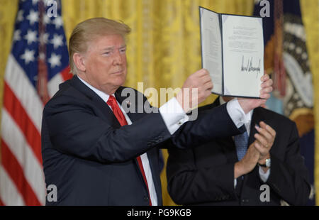 President Donald Trump holds up Space Policy Directive - 3 after signing it during a meeting of the National Space Council in the East Room of the White House, Monday, June 18, 2018, in Washington. Chaired by the Vice President, the council's role is to advise the President regarding national space policy and strategy, and review the nation's long-range goals for space activities. Stock Photo