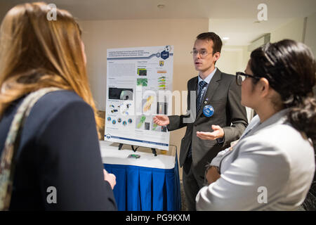 Students and young professionals discuss their projects at the Earth Science Applications Showcase Wednesday, August 1, 2018 at NASA Headquarters in Washington. Every summer, participants in NASA’s Applied Sciences’ DEVELOP National Program come to NASA Headquarters and present their research projects. DEVELOP is a training and development program where students work on Earth science research projects, mentored by science advisers from NASA and partner agencies, and extend research results to local communities. Stock Photo