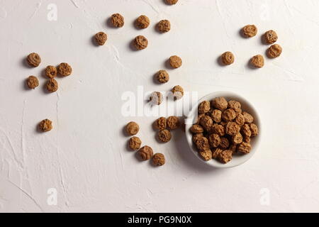 Tigernuts / earth almonds / nutsedges in a small bowl, on white surface, top view Stock Photo