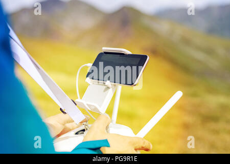 Man hands controlling drone with remote control in Fagaras Mountains, Romania Stock Photo