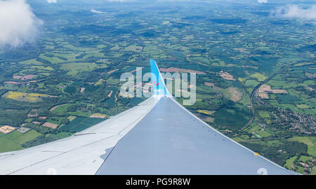 Fly from London Gatwick to Sicily in Italy by TUI Travel Air Shuttle.View from window on plane wing,below English countryside fields visible from air Stock Photo