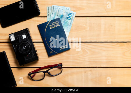 Brazilian Passport on the wooden table and itens for traveling - republica federativa do Brasil, mercosul Stock Photo