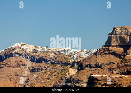 View from a boat to the crater wall of Santorini, Greece with the center of the capital Fira up on the crater rim. Stock Photo