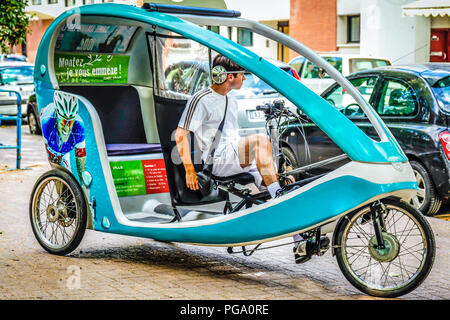 Modern, semi-enclosed Pedicab on the streets of Lille in France Stock Photo