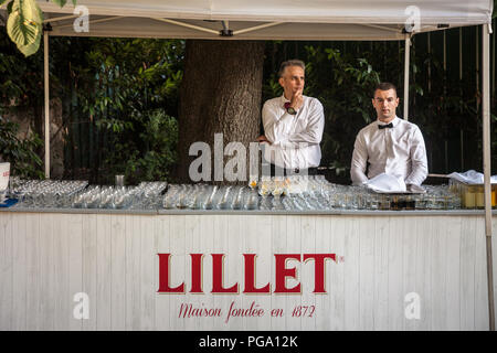 BELGRADE, SERBIA - JULY 14, 2018:  Two waiters standing in front of a Lillet summer bar with its logo and glasses. Lillet is a French brand of aromati Stock Photo