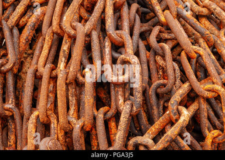 A closeup of a pile of big link old rusty ships anchor chains Stock Photo