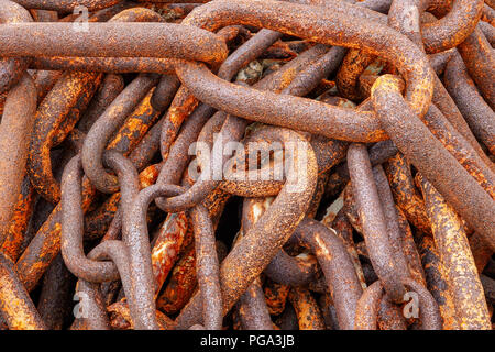 A closeup of a pile of big link old rusty ships anchor chains Stock Photo