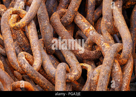 A closeup of a pile of big link old rusty ships anchor chains Stock Photo