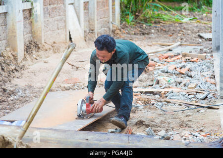 CHIANG MAI, THAILAND - 25 August 2018 - Construction worker cuts construction plywood at a construction site in Chiang Mai, Thailand on August 25, 201 Stock Photo