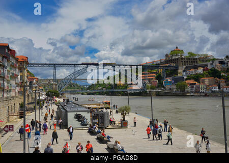 Tourists and locals in the heart of beautiful Porto, the famous bridge 'Ponte Dom Luis I' in the background. Stock Photo