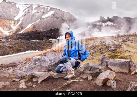 female nature photographer in action in the wild landscape of Landmannalaugar Iceland Stock Photo