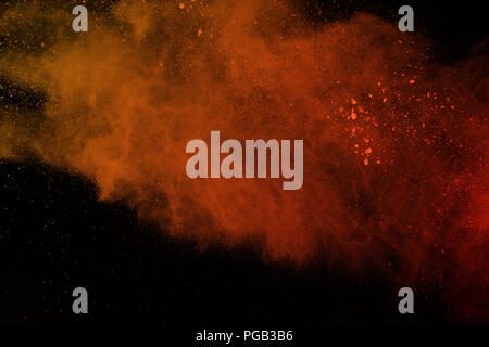 orange powder explosion isolated on black background. Freeze motion of colored dust splatted. Stock Photo