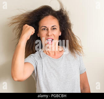 Curled hair brazilian woman annoyed and frustrated shouting with anger, crazy and yelling with raised hand, anger concept Stock Photo