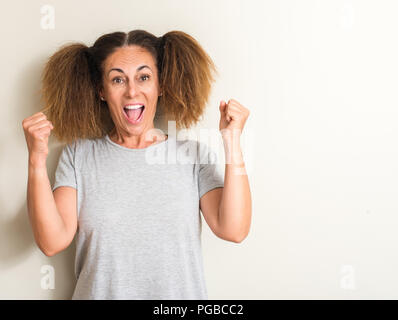 Brazilian woman wearing pigtails screaming proud and celebrating victory and success very excited, cheering emotion Stock Photo