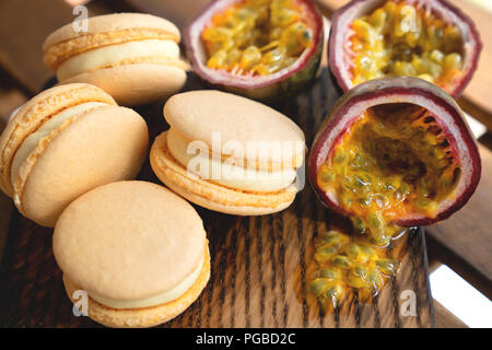 Passion fruit with macarons on wooden background Stock Photo