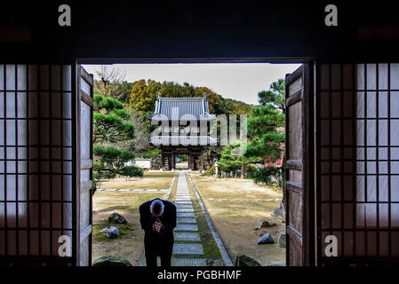 Okayama, Japan: The Japanese Buddhist follower is praying in front of the buddhist temple in Okayama, Japan Stock Photo