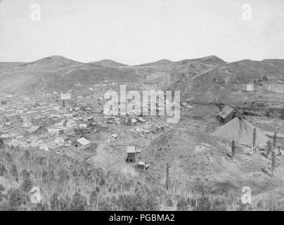 Distant view of mining town; hills in background.