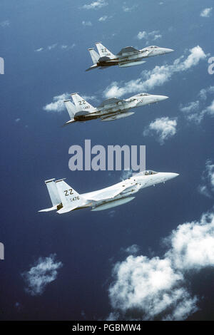 An air-to-air right side view of three F-15 Eagle aircraft armed with AIM-9 Sidewinder air-to-air missiles. Stock Photo