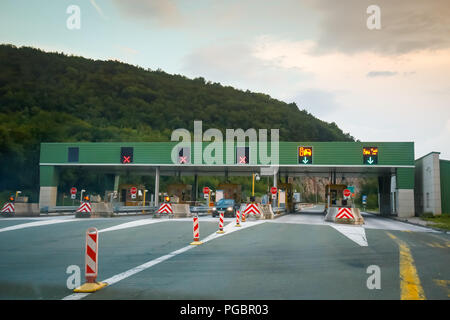 Ostrovica, Croatia - August 1th, 2018 : Cars driving on the highway tollbooth Ostrovica at sunset in Ostrovica, Croatia. Stock Photo