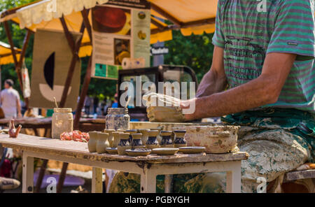 CLUJ-NAPOCA, ROMANIA - JULY 29, 2018: closeup of craftsman making pottey out of clay Stock Photo