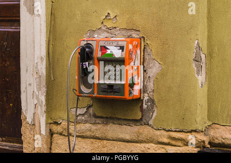 CLUJ-NAPOCA, ROMANIA - JULY 29, 2018: abandoned payphone on old rustic building in Cluj, Transylvania Stock Photo