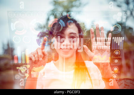 girl using advance technology of computer hologram air screen display mix media business information data chart outdoor Stock Photo
