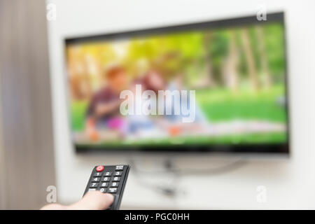 people watching tv hand with remote control smart television Stock Photo
