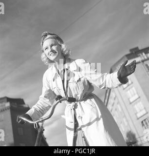 1940s woman on a bicycle. The Swedish actress Karin Nordgren is holding out her hand to give sign that she will turn left. Sweden 1940. Photo Kristoffersson 157-13 Stock Photo