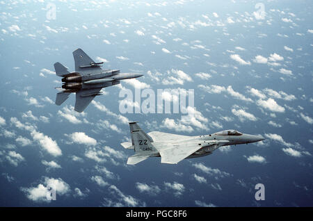 An air-to-air right side view of two F-15 Eagle aircraft.  The F-15 in the background is banking to the left. Stock Photo