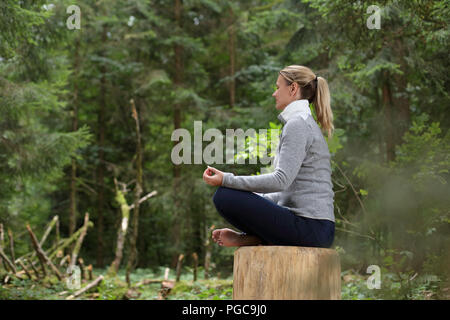 A Woman relaxing meditation in a Forest Stock Photo