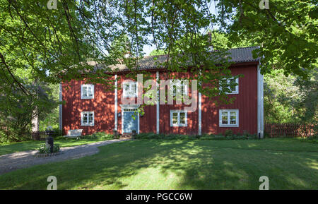 PERSHYTTAN, SWEDEN ON MAY 18, 2018. Outdoor view of a wooden building, garden this side. Late evening and shadows. Editorial use Stock Photo